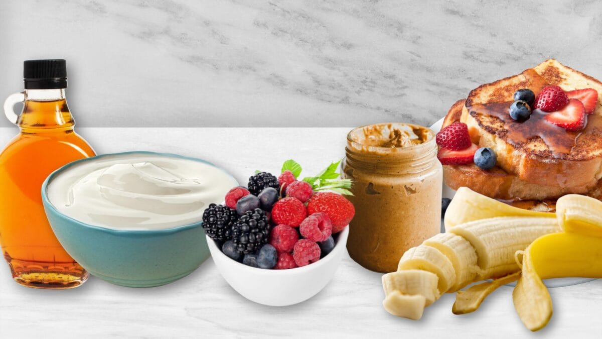 picture of topping elements like a jar of honey, yogurt, berries, nut butter and bananas